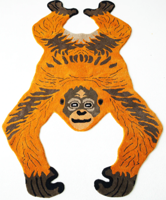 Monkey-shaped rug with orange and black design on a white background