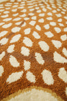 Close up of Amy the Antelope Rug. Cream spots on orange rug by Studio 321B